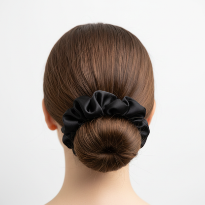 Midnight black silk scrunchie worn in an elegant low bun